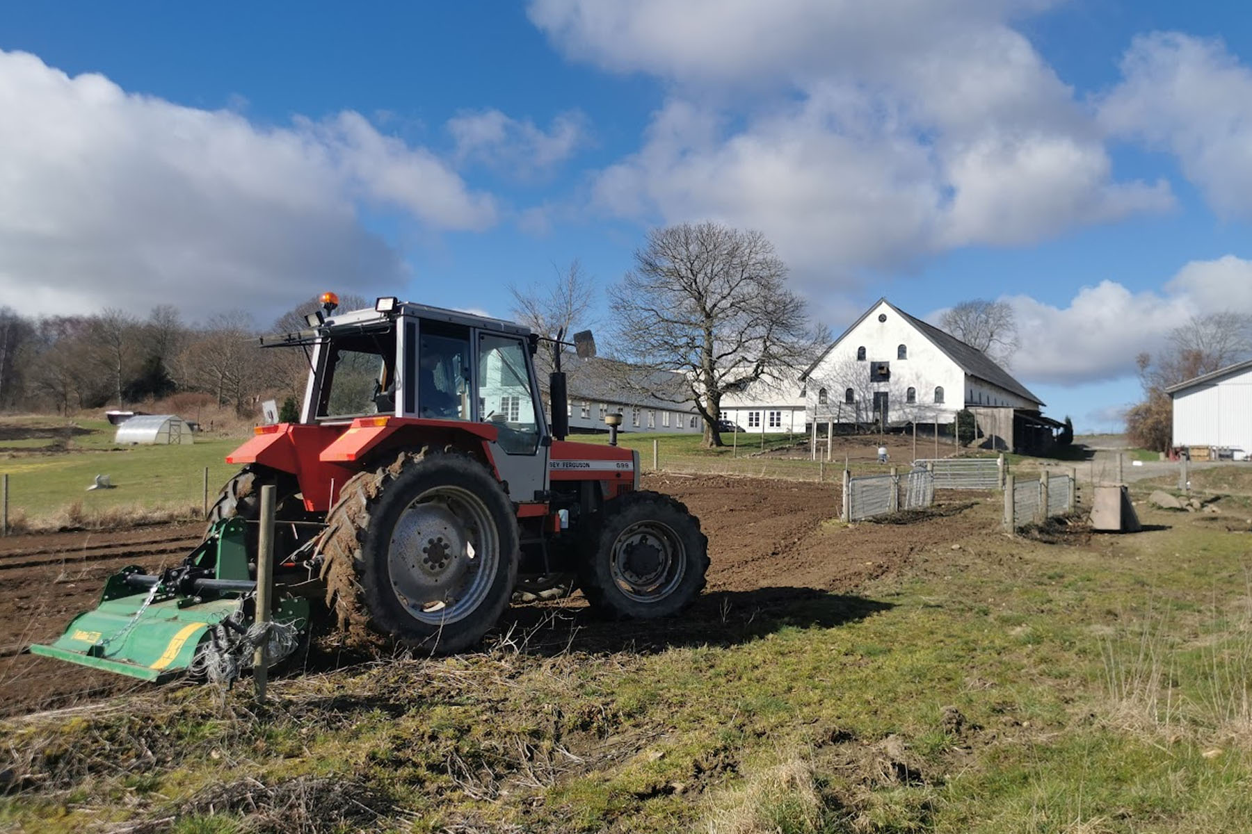 Traktor med gård i baggrund