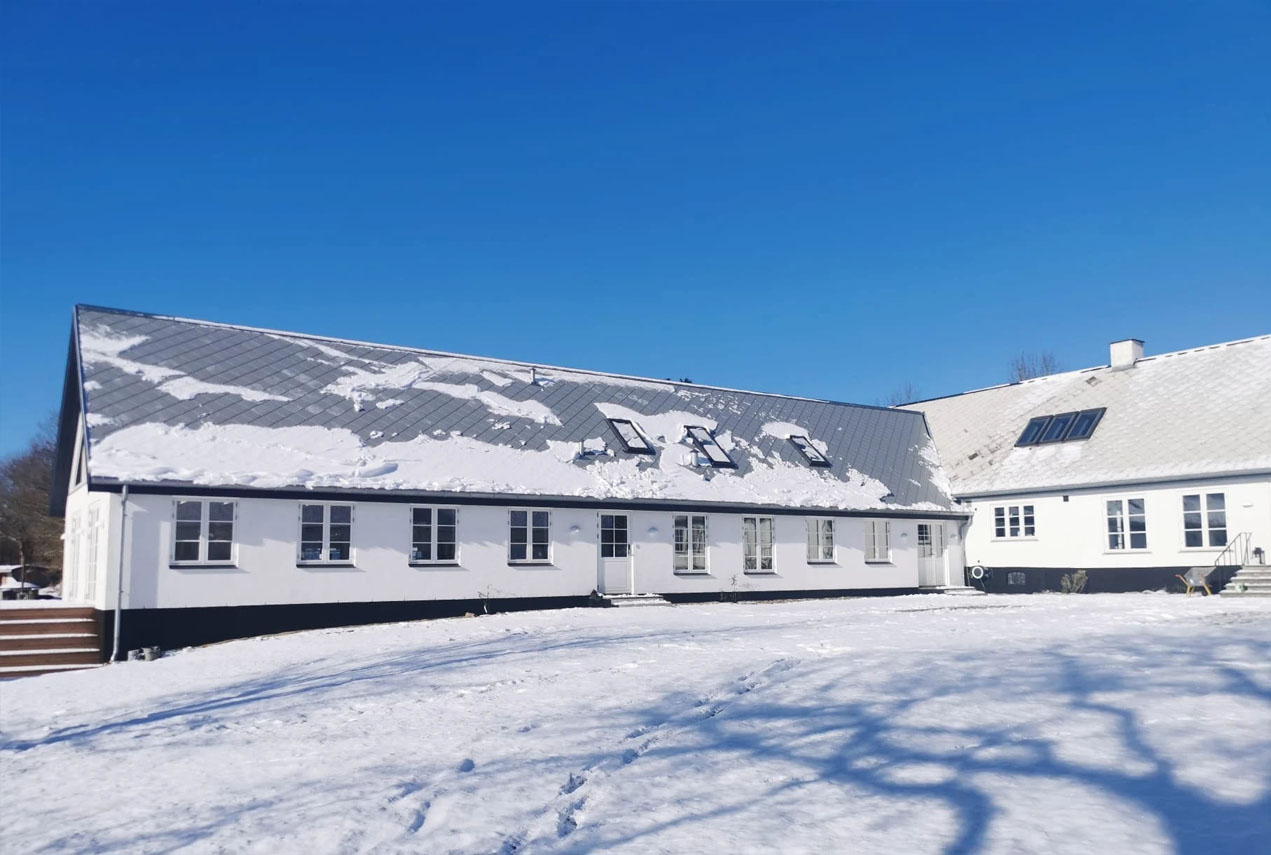 Gård med blå himmel og sne