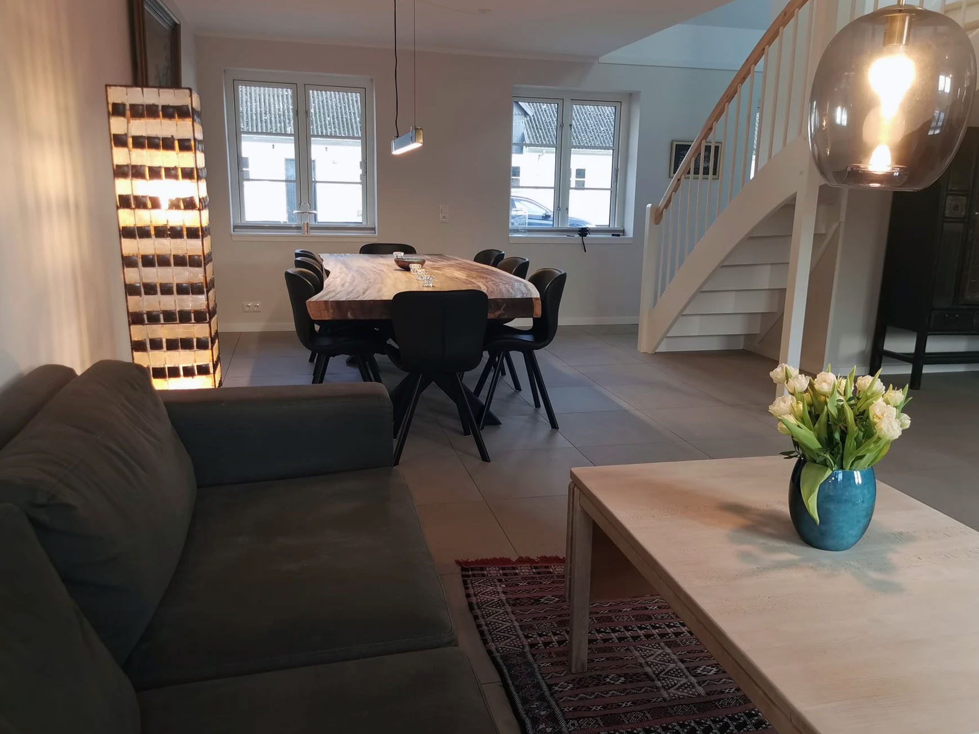 Spisestue med spisebord, sofa og sofabord med trappe til første sal