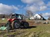 Traktor med gård i baggrund